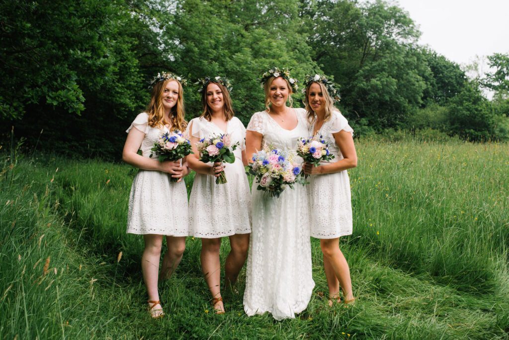 celebrating amazing women - a bride in Bo-ho dress and bridesmaids in short dress, all off white in a meadow