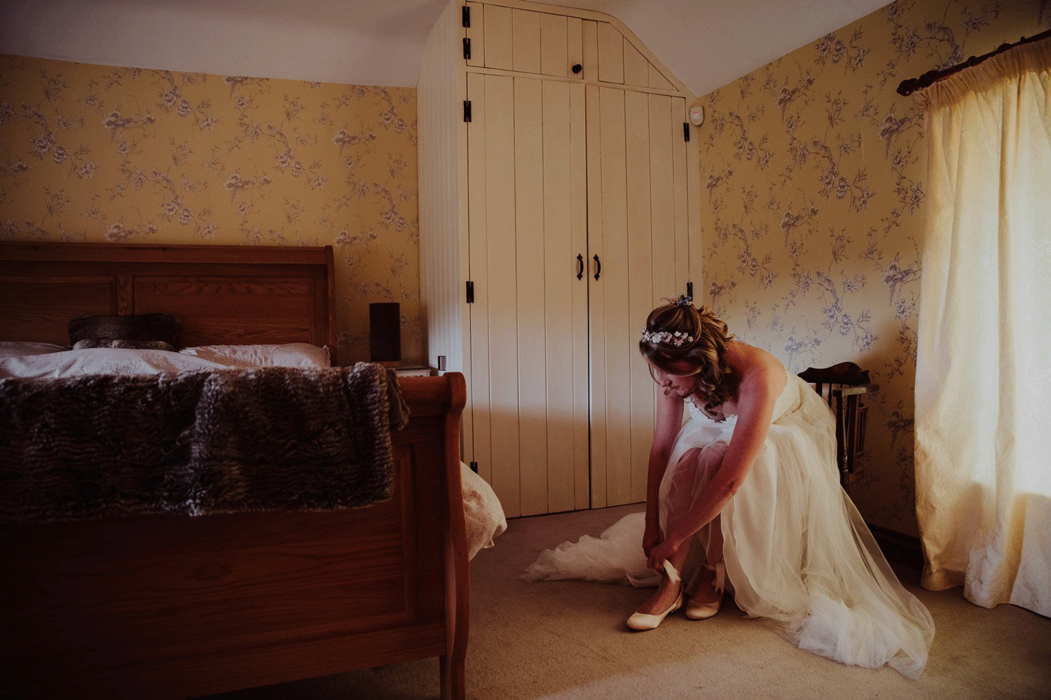 Bride in a bedroom putting her shoes on