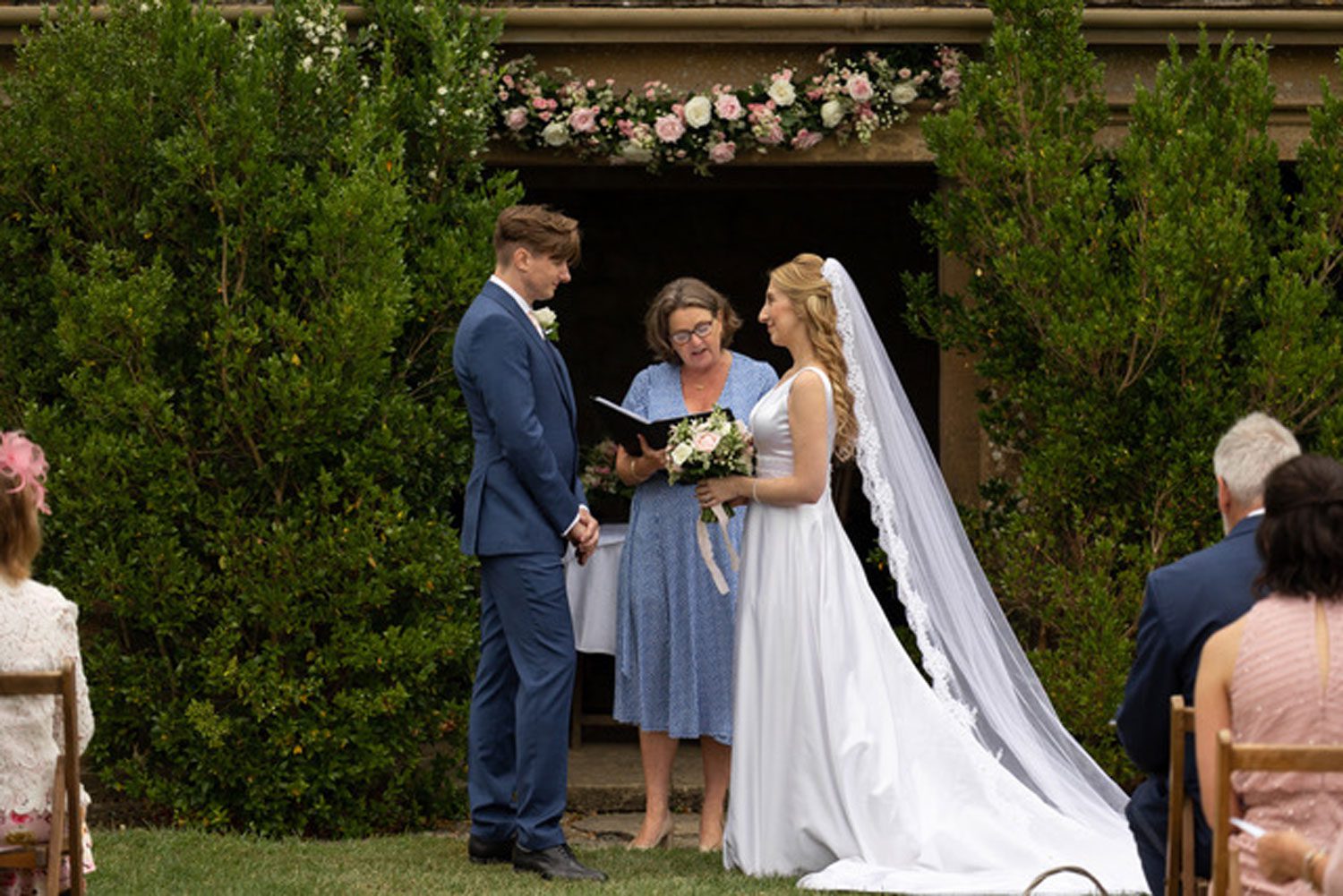 are registrars and celebrants the same? A young couple stand before Celebrant Fan in an outdoor ceremony