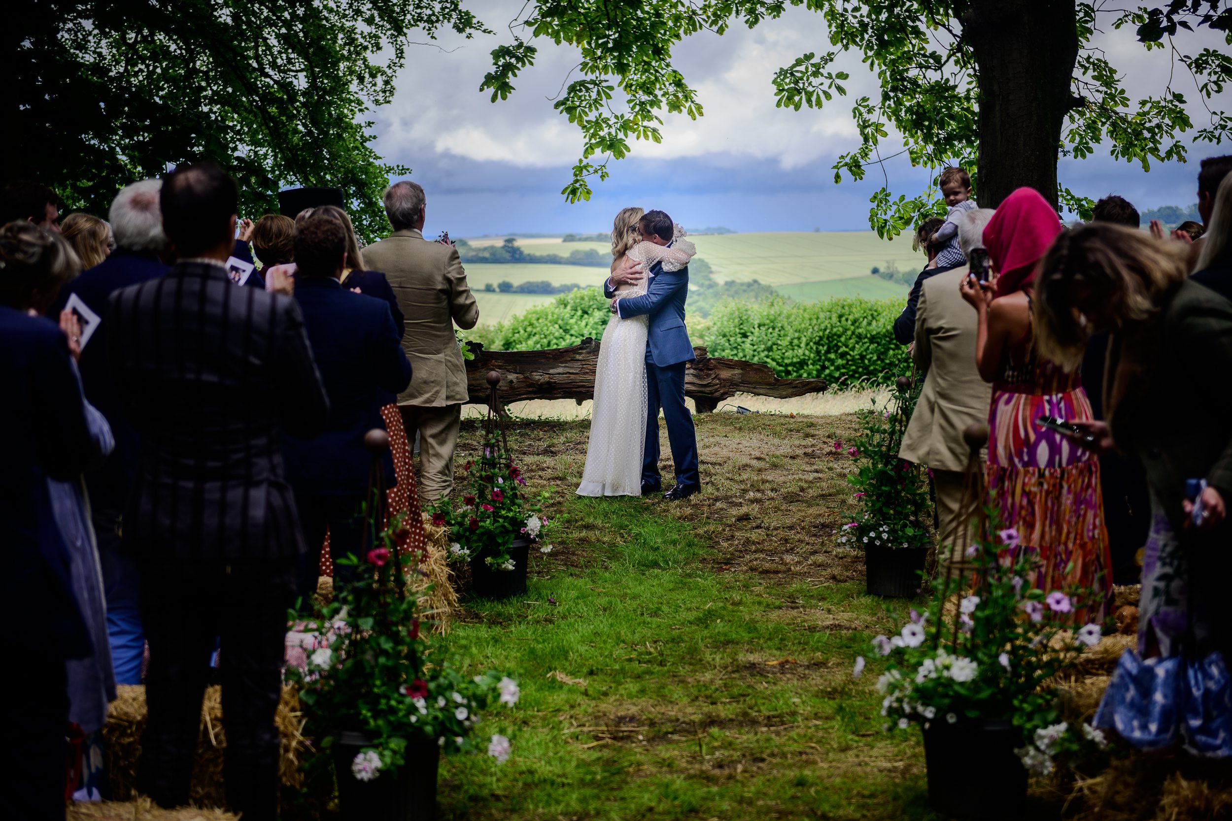 unforgettable wedding ceremony where the bride and groom, married outside in beautiful landscape, embrace to  the applause of their guests