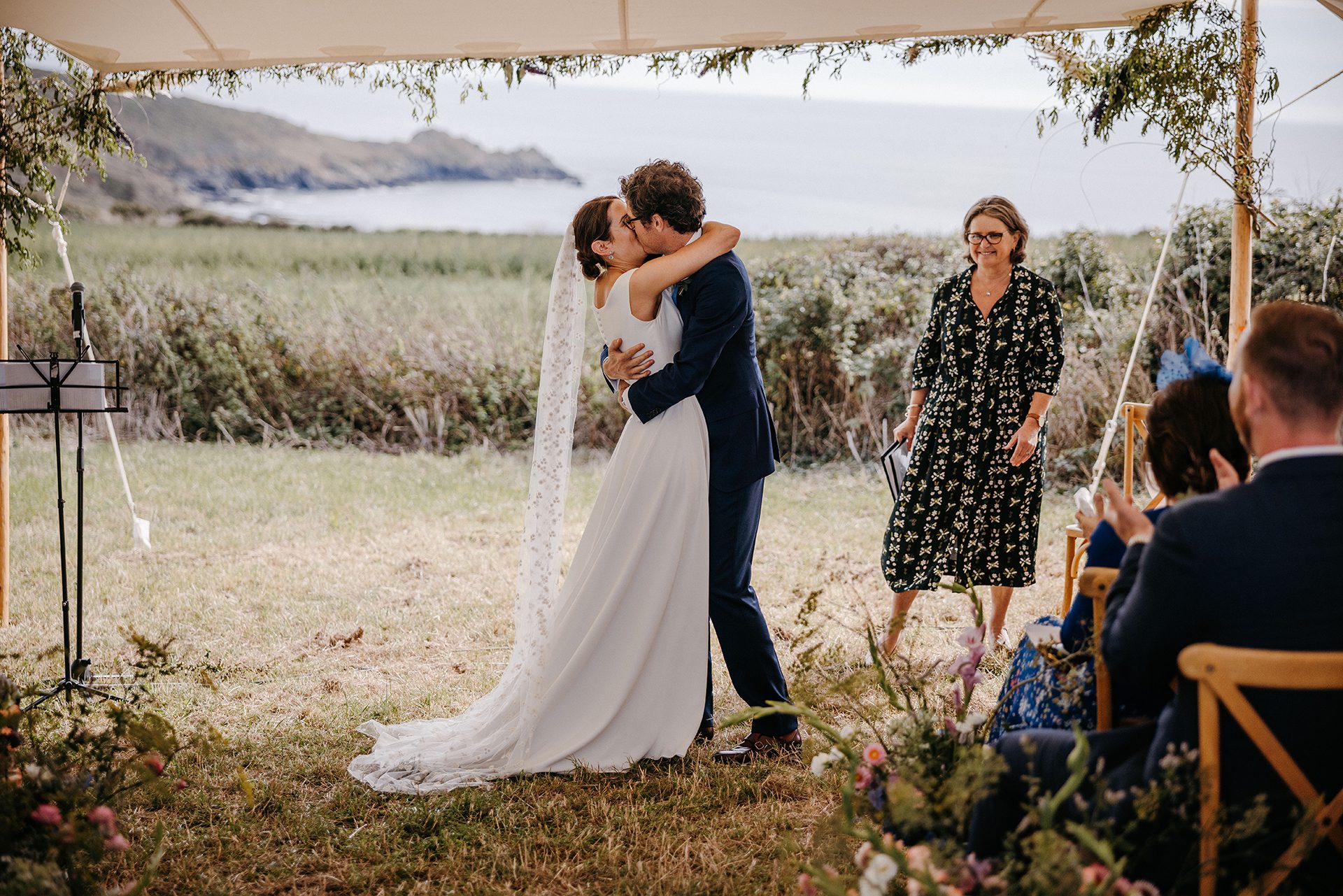 Registrar wedding ceremonies cannot take place under a canopy, like this one, where the bride and groom are kissing in front of their guests