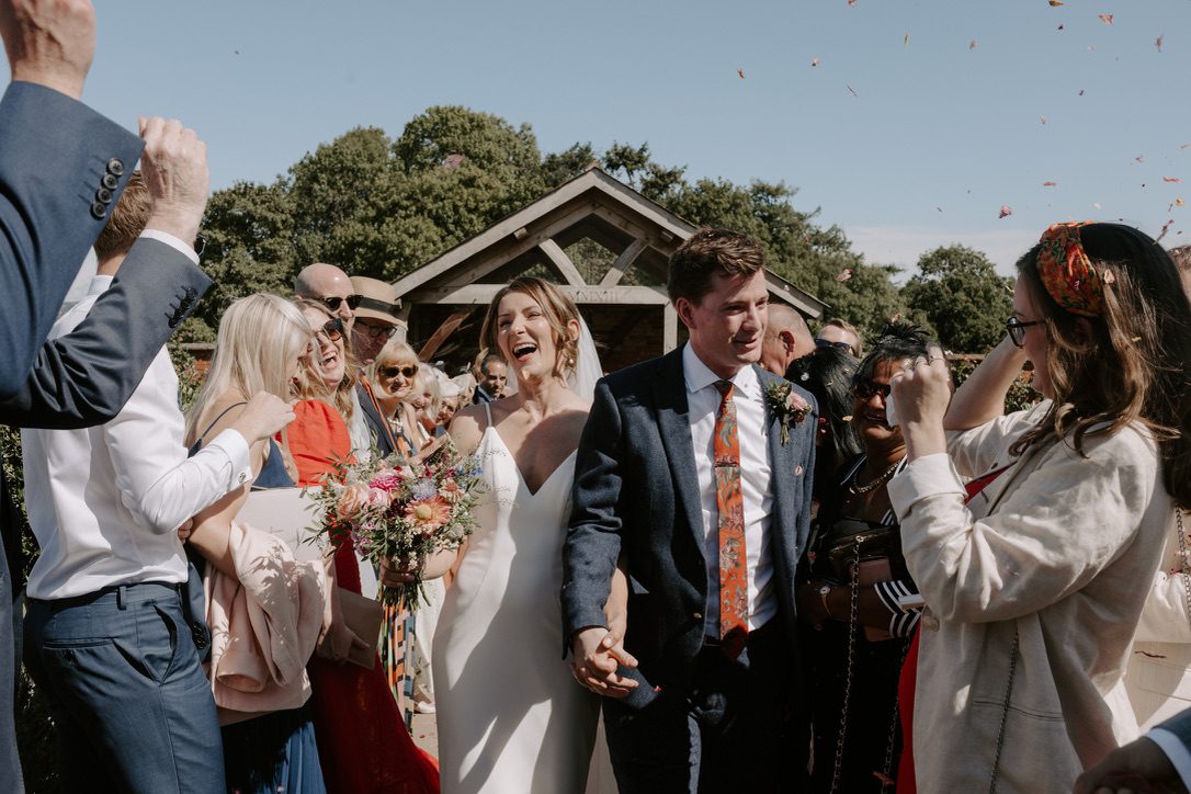 non religious wedding ceremonies can still be traditional, this couple are walking through their guests showered in confetti