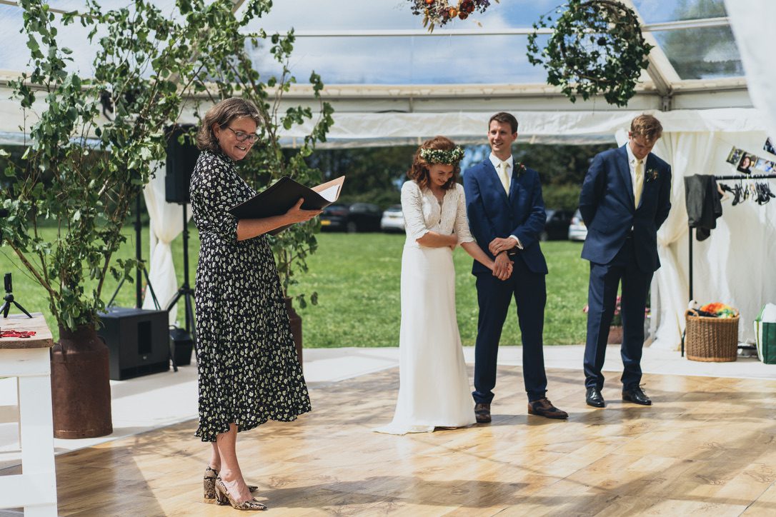 Do registrars offer personal ceremonies like this one under an open marquee, the celebrant is reading from a folder