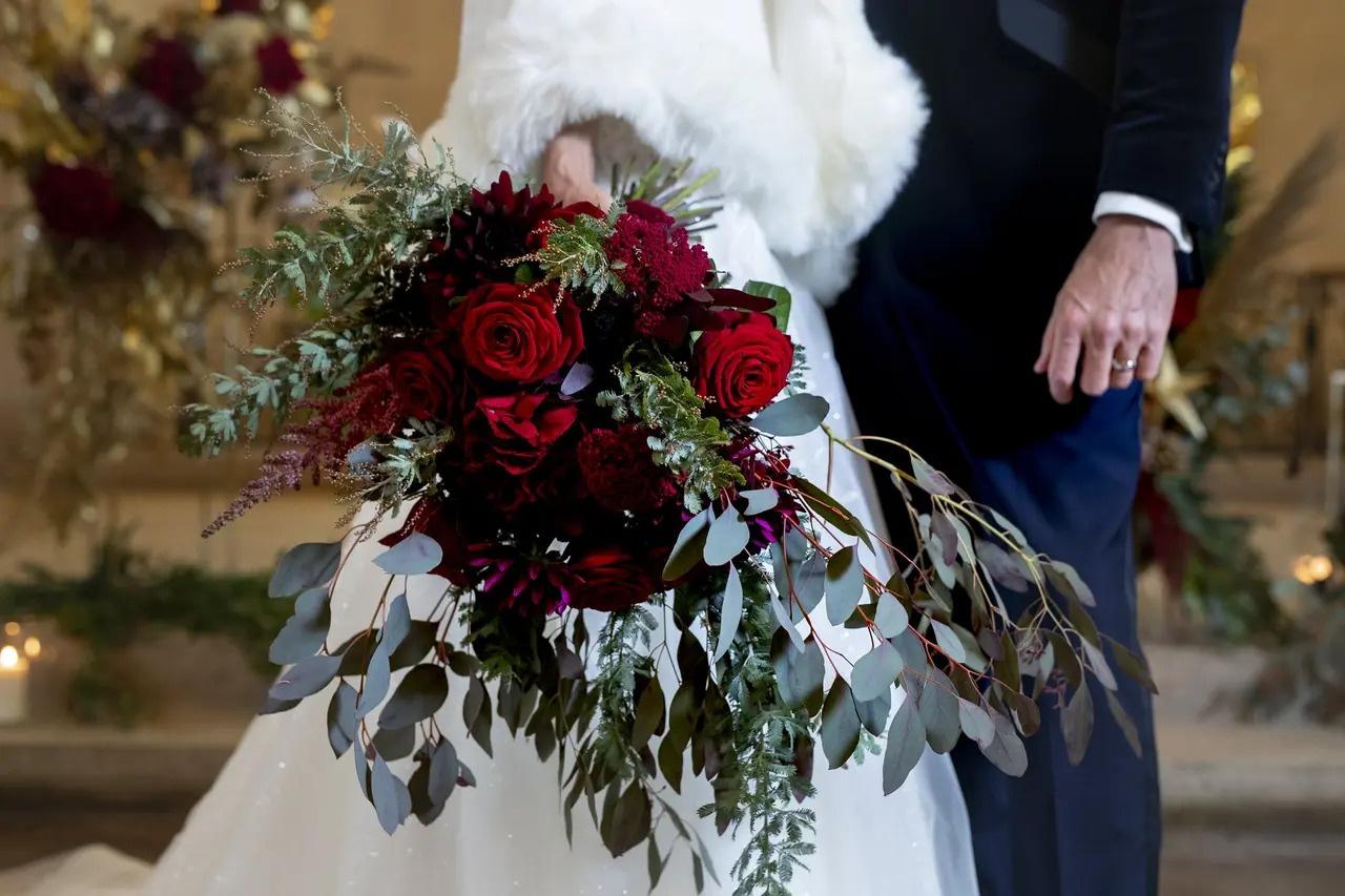 Valentine's Day wedding bride and groom with a bouquet of red roses