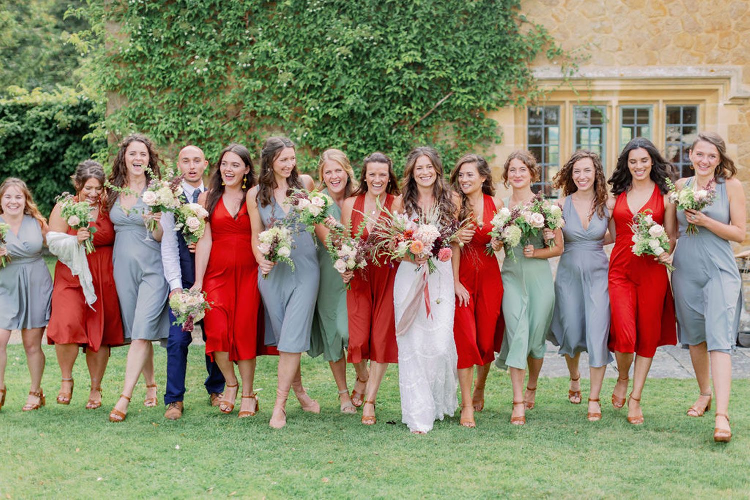 Celebrating amazing women a bride with her bridesmaids alternatively dressed in grey and red.