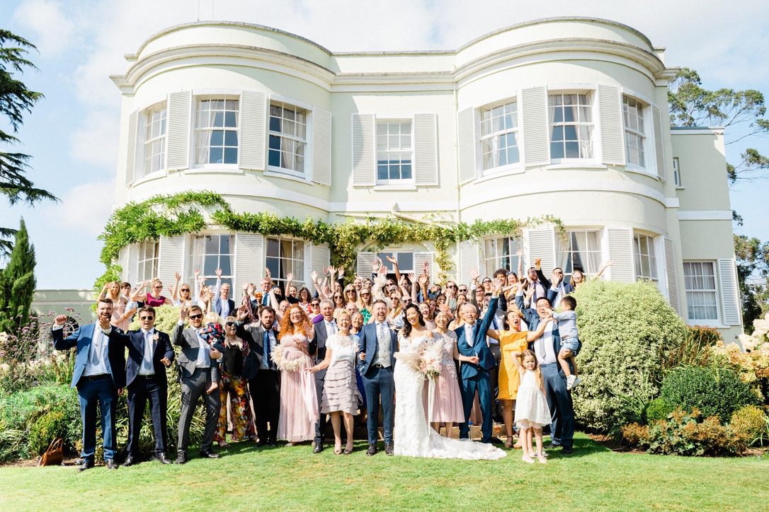 Tara Statton Photography a very happy wedding party standing outside deer park country house a white georgian house and a beautiful wedding venue in devon
