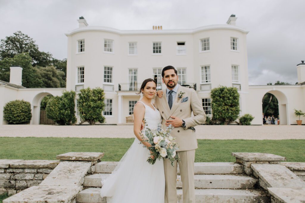couple standing in front of rockbeare manor a wonderful example of a regency bridgerton wedding venue 
