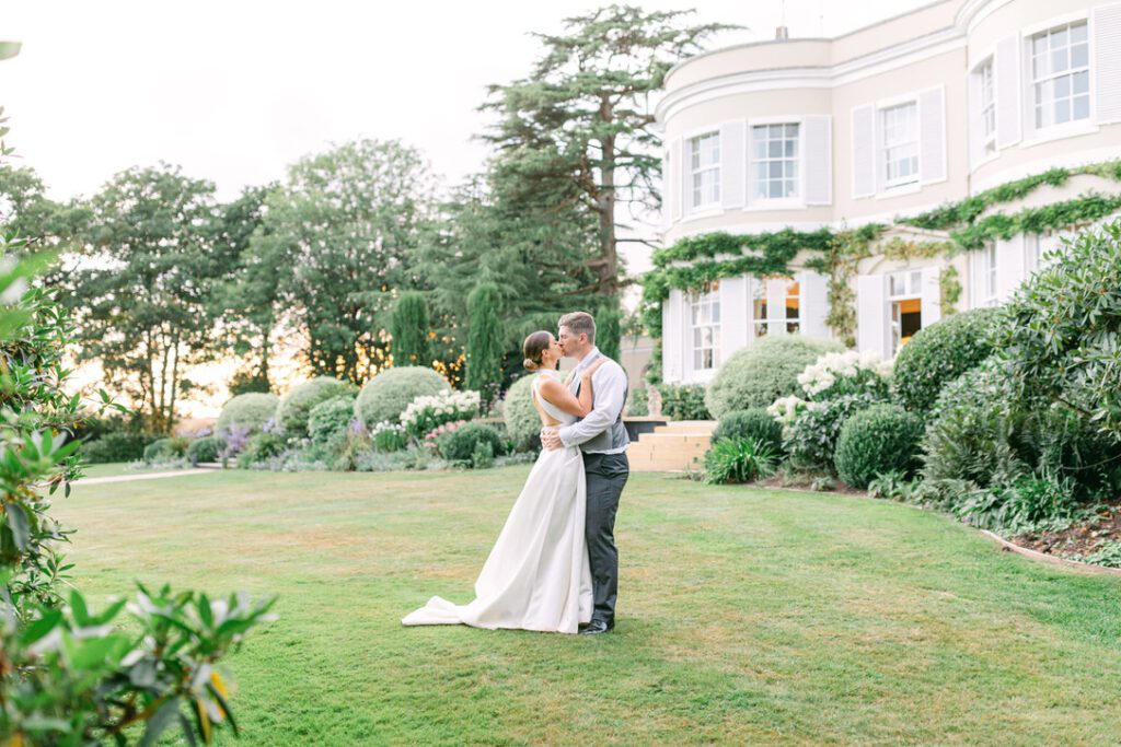 bride and groom kissing standing outside the beautiful wedding venue Deer Park Country House