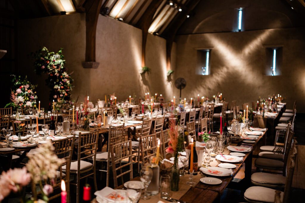 Tables laid for a wedding in The Great Barn, Devon