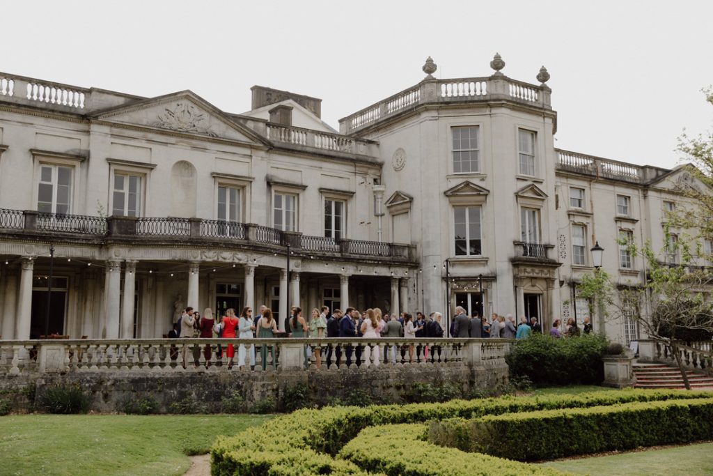 grove house with guests gathered outside for wedding reception 