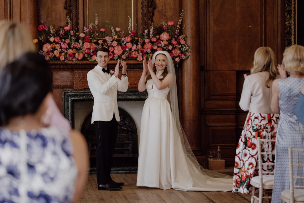 groom in tuxedo and black tie and bride applauding during wedding ceremony script 