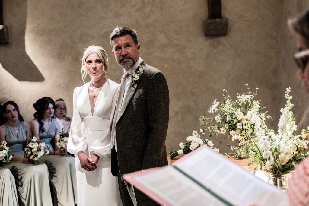 Couple listening attentively to wedding celebrant reading the wedding ceremony scrips
