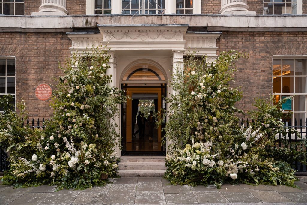 floral arrangements with white flowers adorning front door of RSA wedding venue in London 