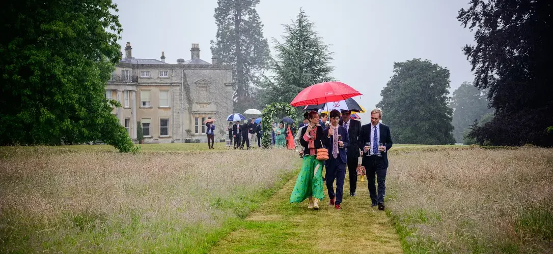 Celebrant philosophy - despite the guests walking in the rain here down a lawn path the experience is joyful