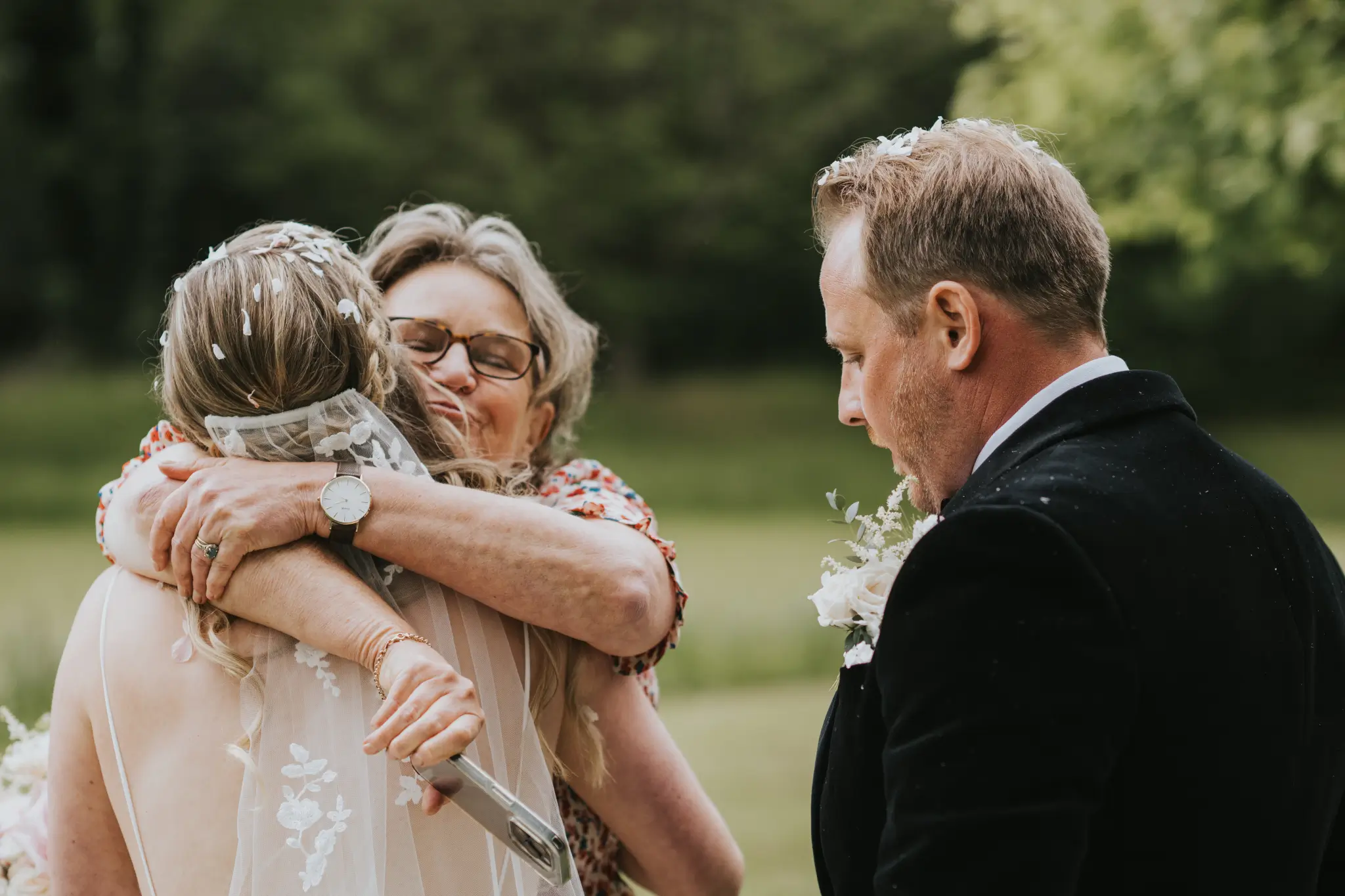 English wedding celebrant Fan hugging bride Tori with Kieran the groom at her side